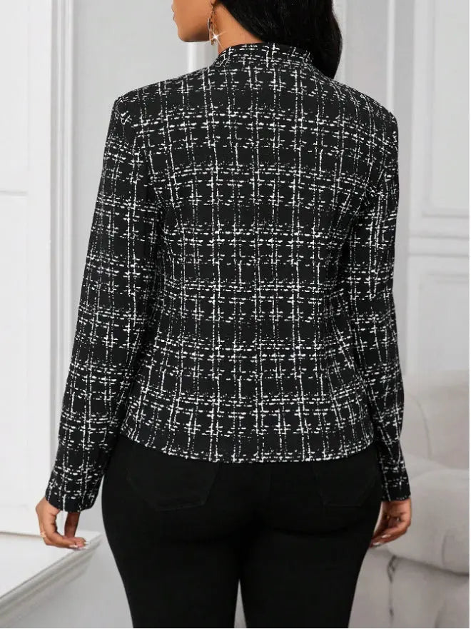 Black and white checkered blazer worn by a person against a neutral background