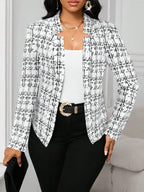 Woman wearing a black and white checkered blazer with a white top and black pants.